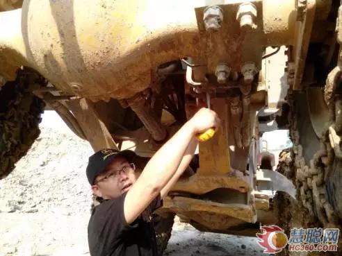 谢辉玉在施工现场对约翰迪尔WL56装载机进行检修
